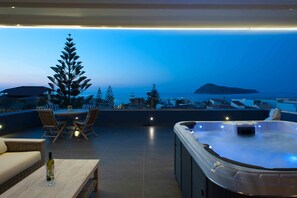 A rooftop terrace with a hot tub, seating area, and a view of the sea. - Frideriki Studios & Apartments (Platanias)