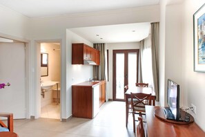 A compact living space with a kitchenette, a dining area, and a bathroom.