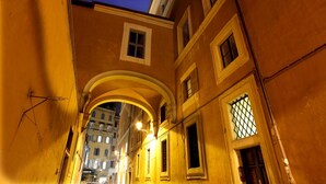 A narrow alleyway with buildings on either side, featuring arched doorways and windows. - Vivaldi Luxury Rooms (Rome)