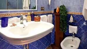 A bathroom with a sink, bidet, and mirror. - Domus Livia Luxury Suites (Rome)