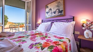 A hotel room with a bed, a painting, a window, and a view of the outside. - Alla Dimora Altea (Florence)