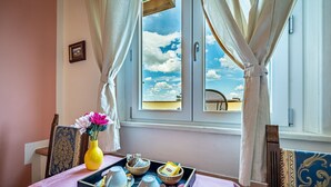 A room with a table set for breakfast, a window with curtains, and a view of the sky. - Alla Dimora Altea (Florence)