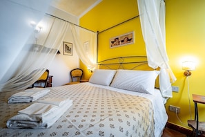 A bed with a canopy, a bedside table, a lamp, and a picture on the wall. - Alla Dimora Altea (Florence)