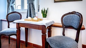 A dining area with a table, two chairs, a potted plant, and a painting on the wall. - Alla Dimora Altea (Florence)