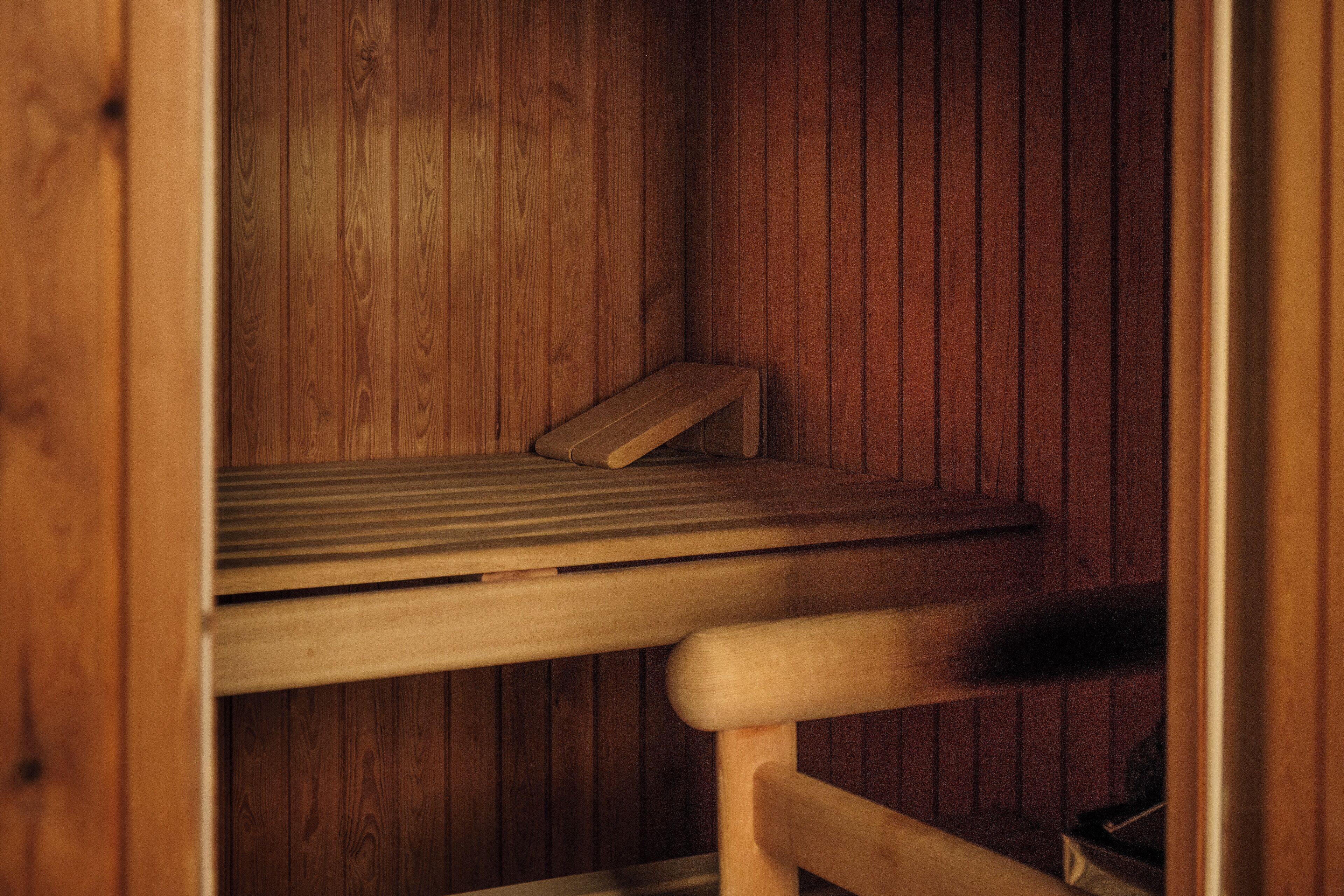 Una sauna de madera con un banco y un asiento.