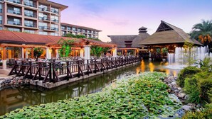 A hotel with a water canal, lily pads, and a traditional building with a sloped roof. - IC Hotels Green Palace & Villas - All inclusive (Antalya)