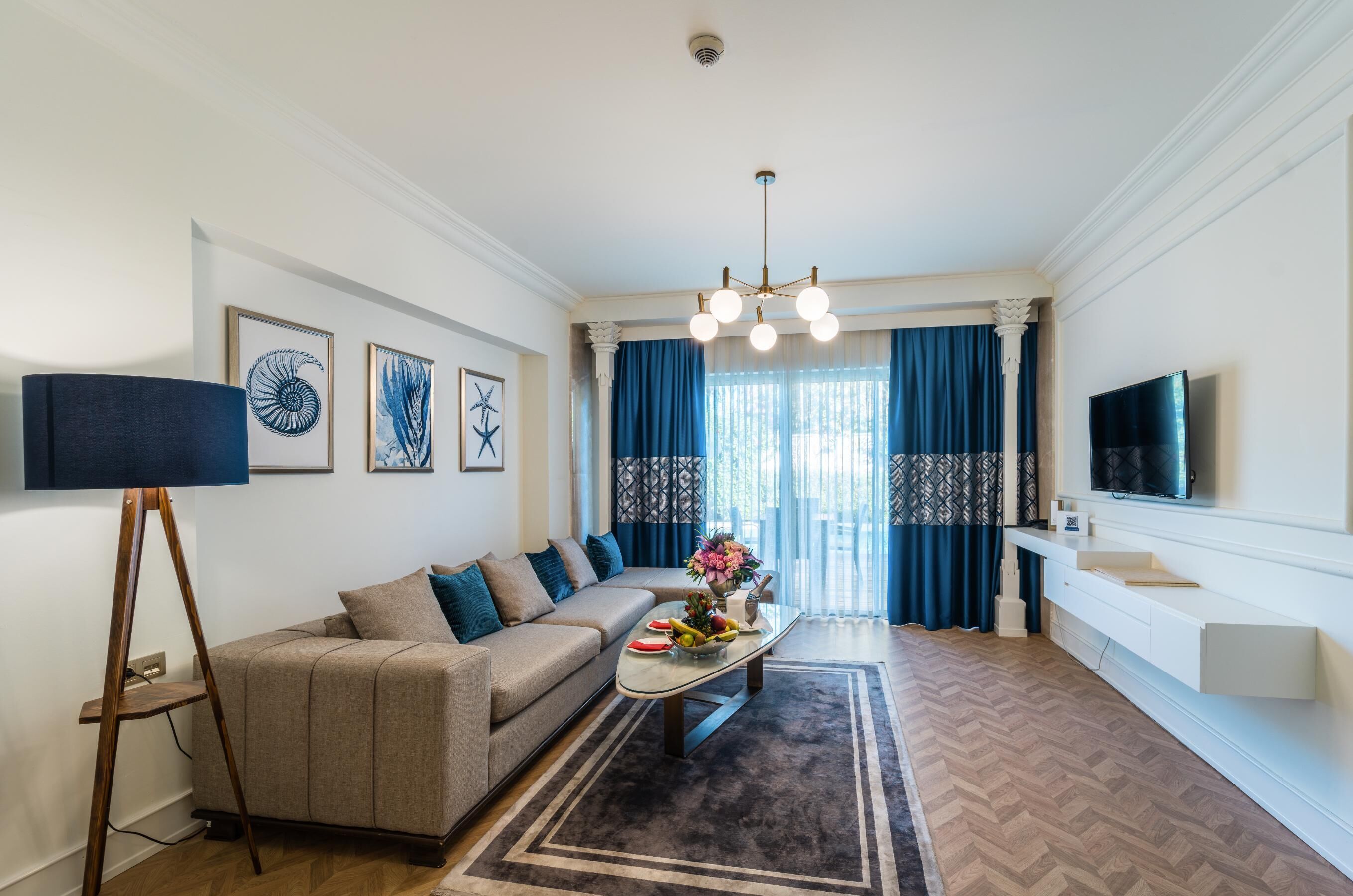A living room with a sofa, coffee table, and artwork on the walls.