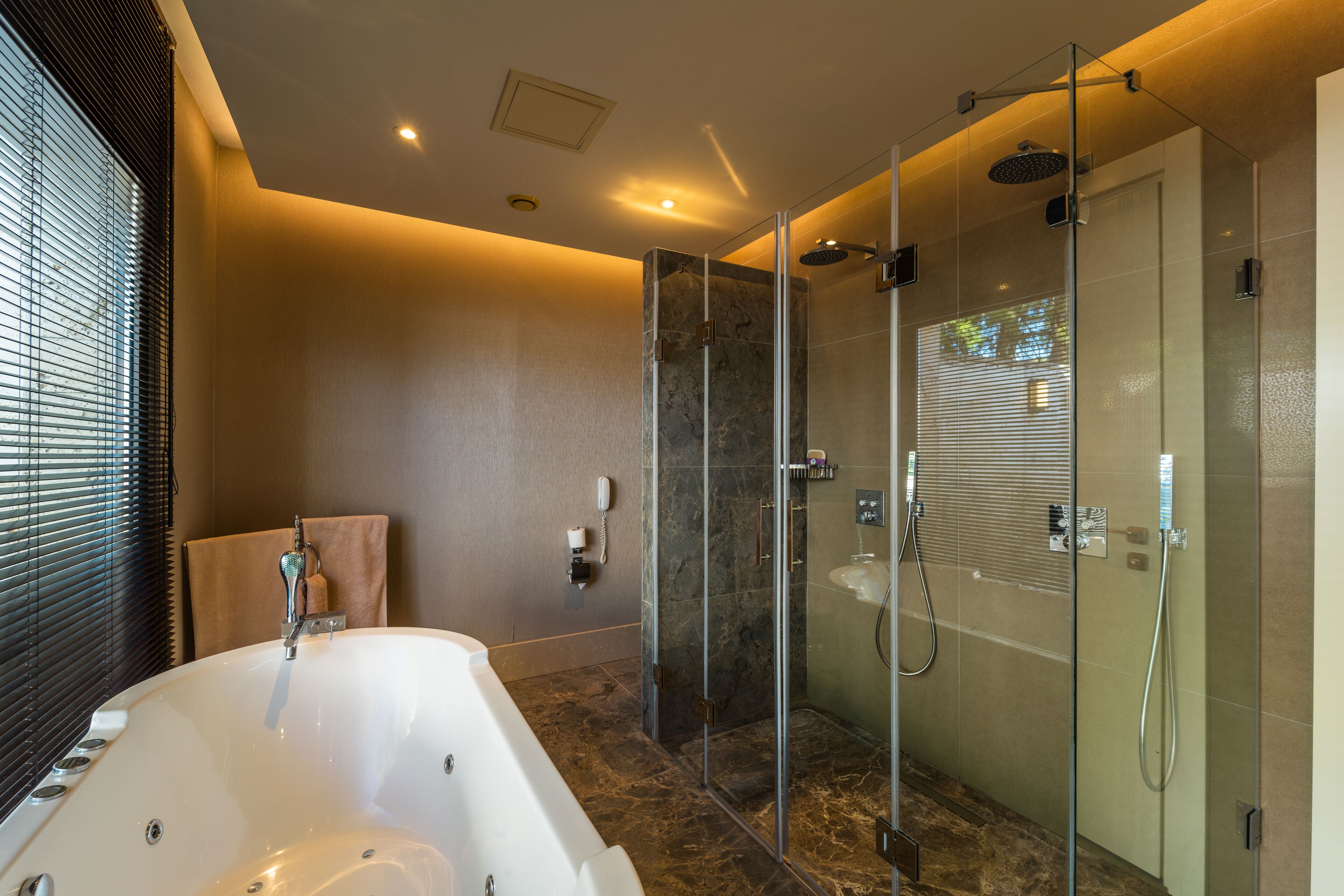 A modern bathroom with a freestanding bathtub, a glass-enclosed shower, and a vanity with a sink and mirror.