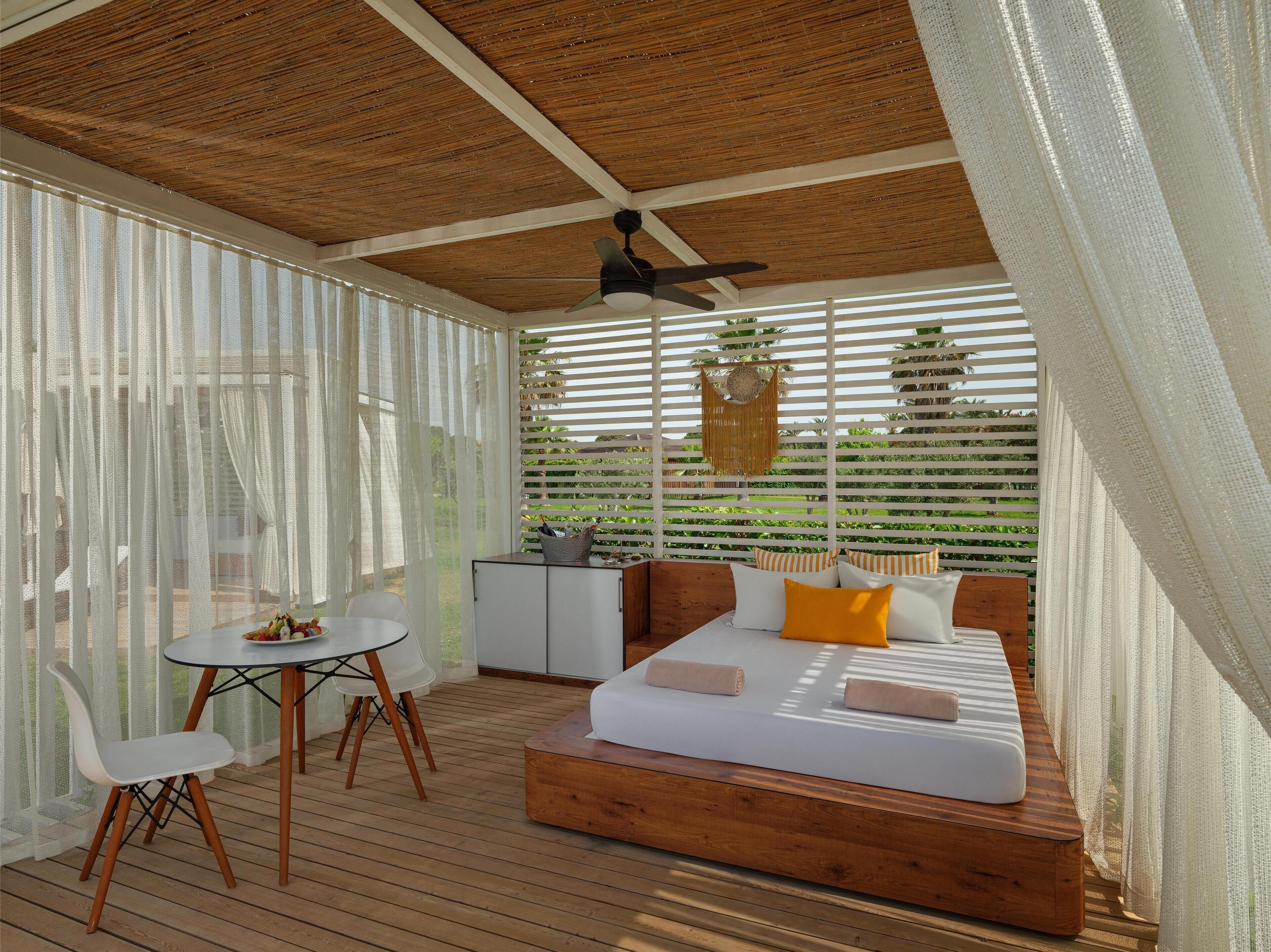 A cozy outdoor seating area with a wooden bench, a small table, and chairs.