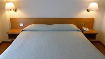 A standard hotel room with a single bed, two bedside tables, and a telephone on one of the tables.
