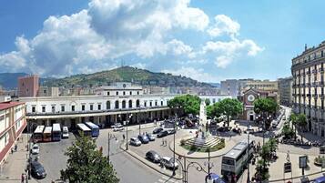 Una plaza urbana con un monumento central, rodeada de edificios históricos y un cielo despejado.
