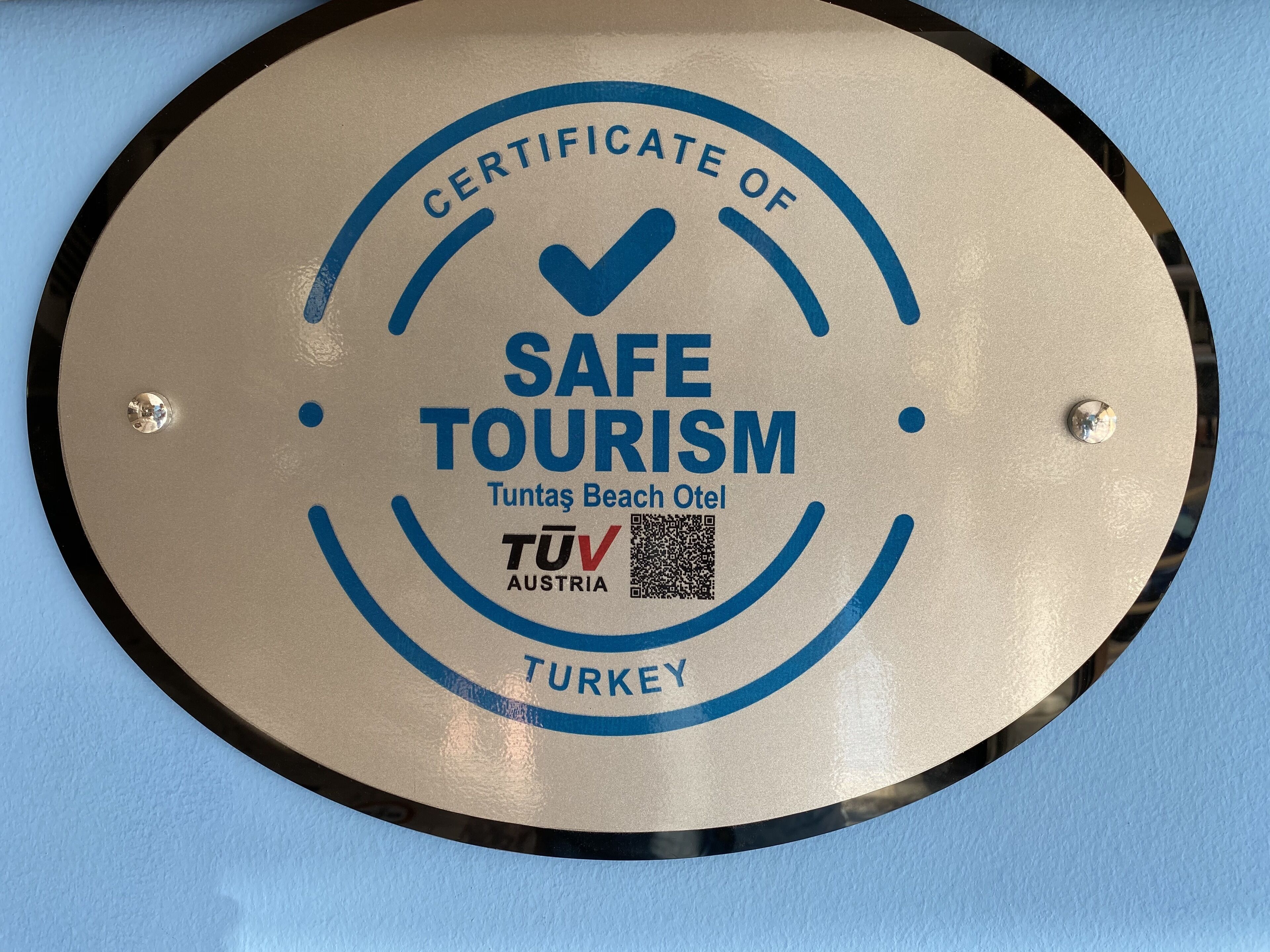 Un letrero circular con la inscripción 'CERTIFICATE OF SAFE TOURISM' y 'TÜV AUSTRIA TURKEY', que indica una certificación de seguridad.