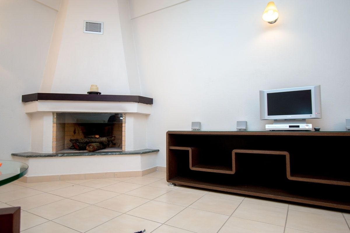 A living room with a fireplace, a television, and a modern entertainment unit.
