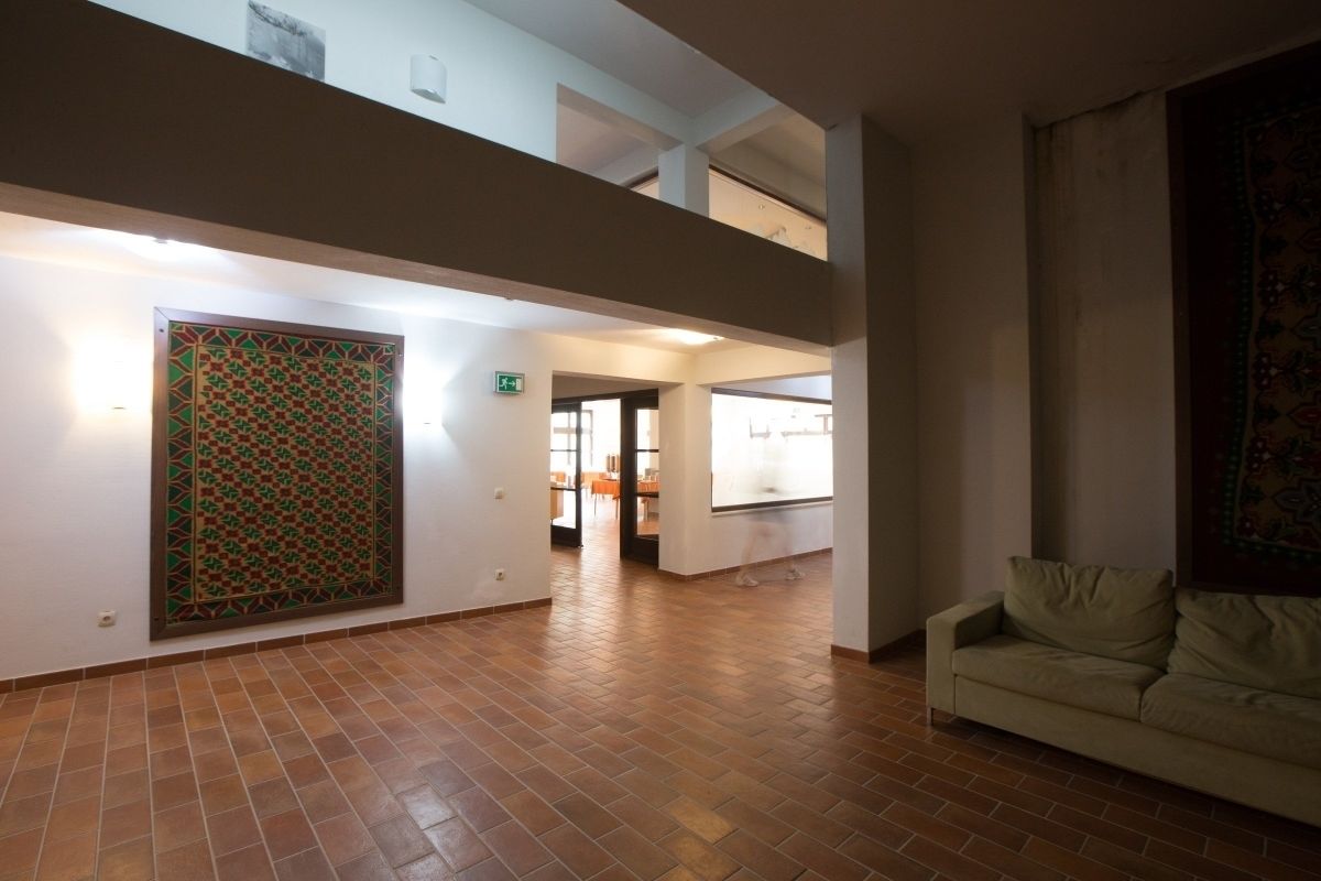 A spacious interior with a tiled floor, a sofa, and a patterned wall.