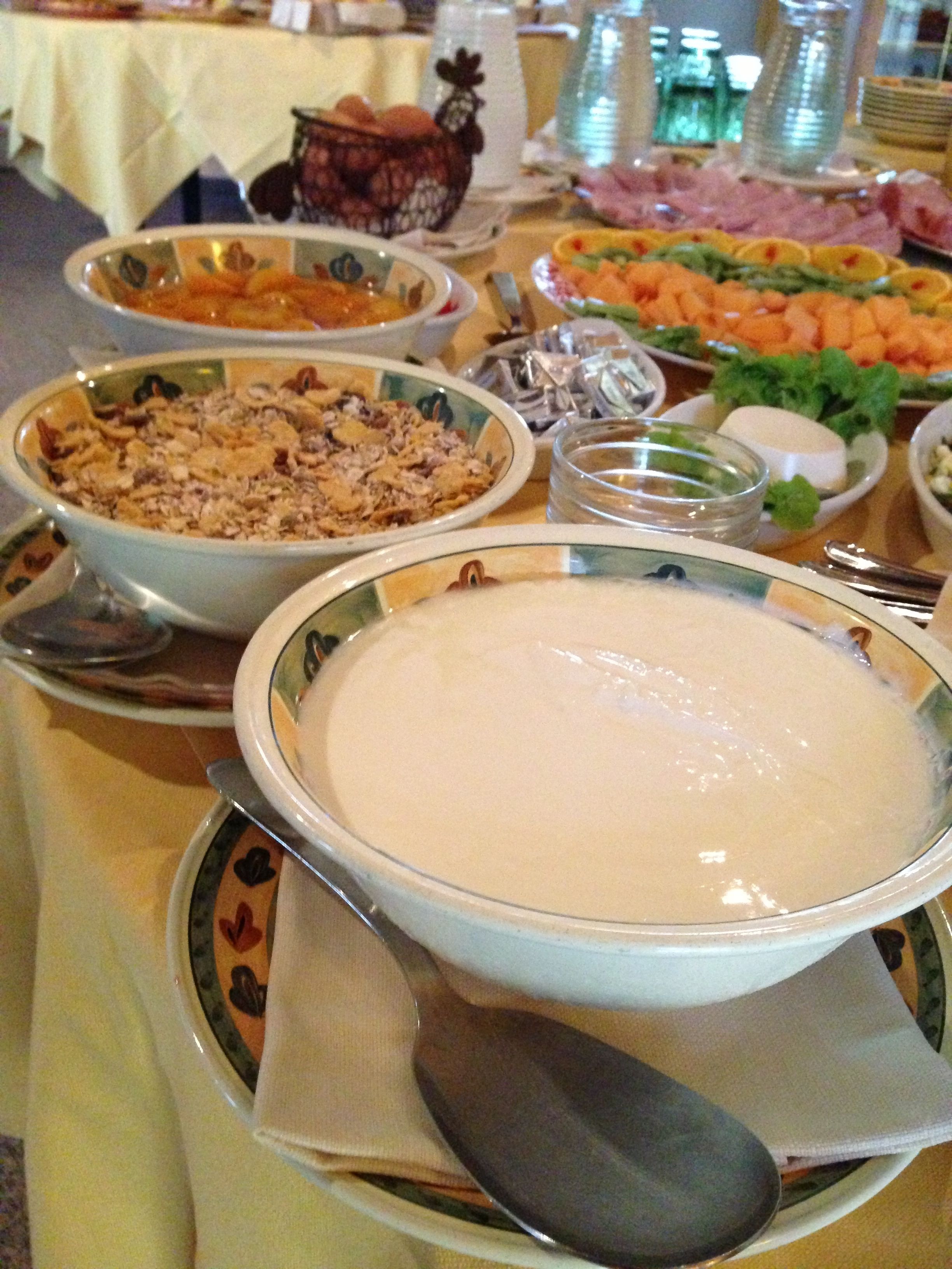 A buffet table with various dishes including a large bowl of soup, salads, and other food items.