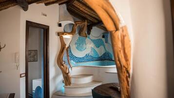 Un escalier avec une rampe en bois et un mur décoré de mosaïques.