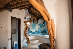 Una escalera con barandilla de madera y pared de mosaicos.