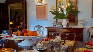 Een eettafel gedekt met een fruitschaal, theepot en diverse borden.