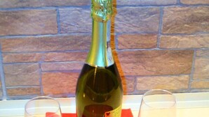 A bottle of champagne on a table with two glasses and a red cloth. - Nuova Fiera Aparthouse (Rome)