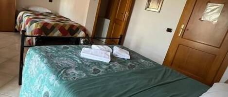 Un dormitorio con una cama, una silla, una puerta y una ventana.