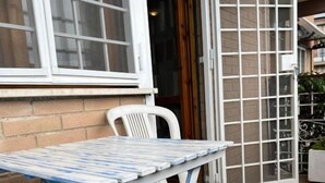 A patio area with a table and chairs, a door, and a brick wall. - Nuova Fiera Aparthouse (Rome)