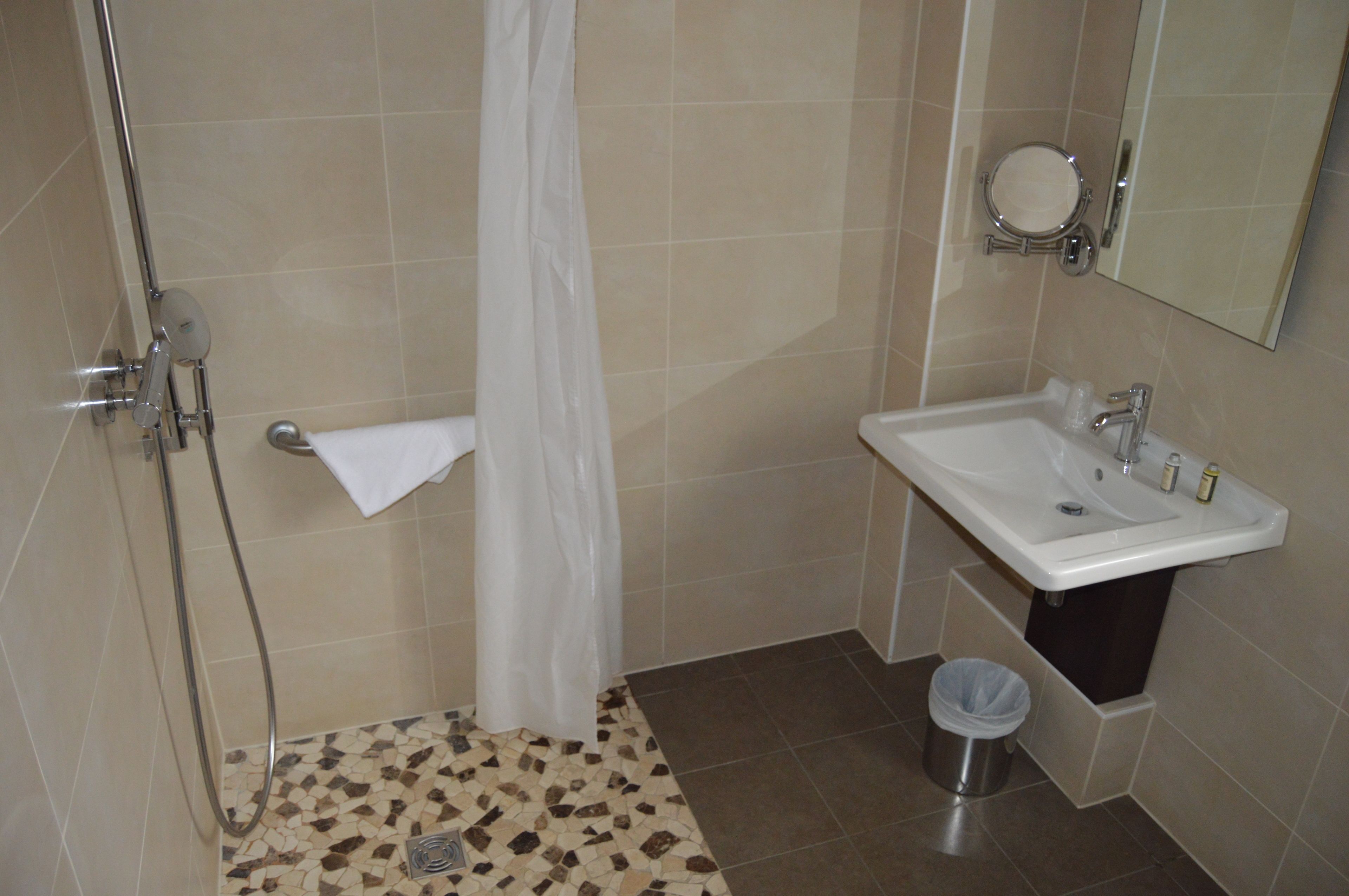 A bathroom with a shower, sink, and toilet.