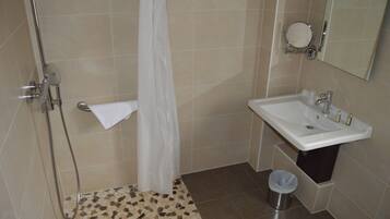 Une salle de bain avec une douche, un lavabo et des toilettes.
