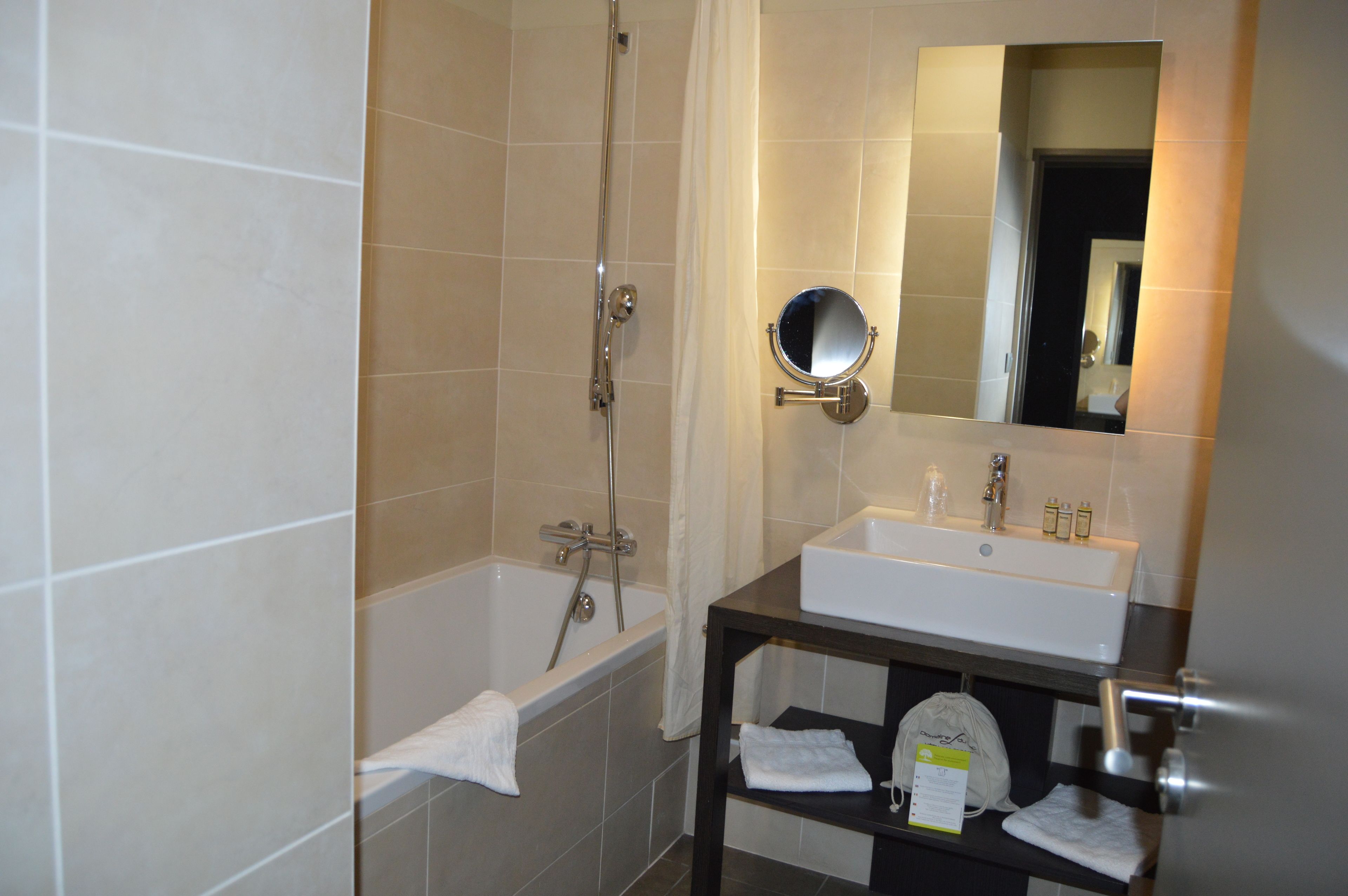 A bathroom with a bathtub, a sink, and a mirror.