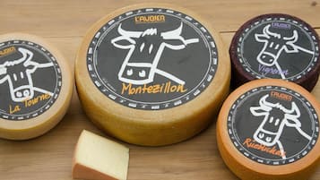 Four cheese wheels with labels 'La Tourne', 'Montezillon', 'Vigneron', and 'Rieblickas'.
