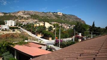 Une ville située sur une colline, avec des bâtiments, une route et une structure imposante qui se dresse au sommet de la colline.