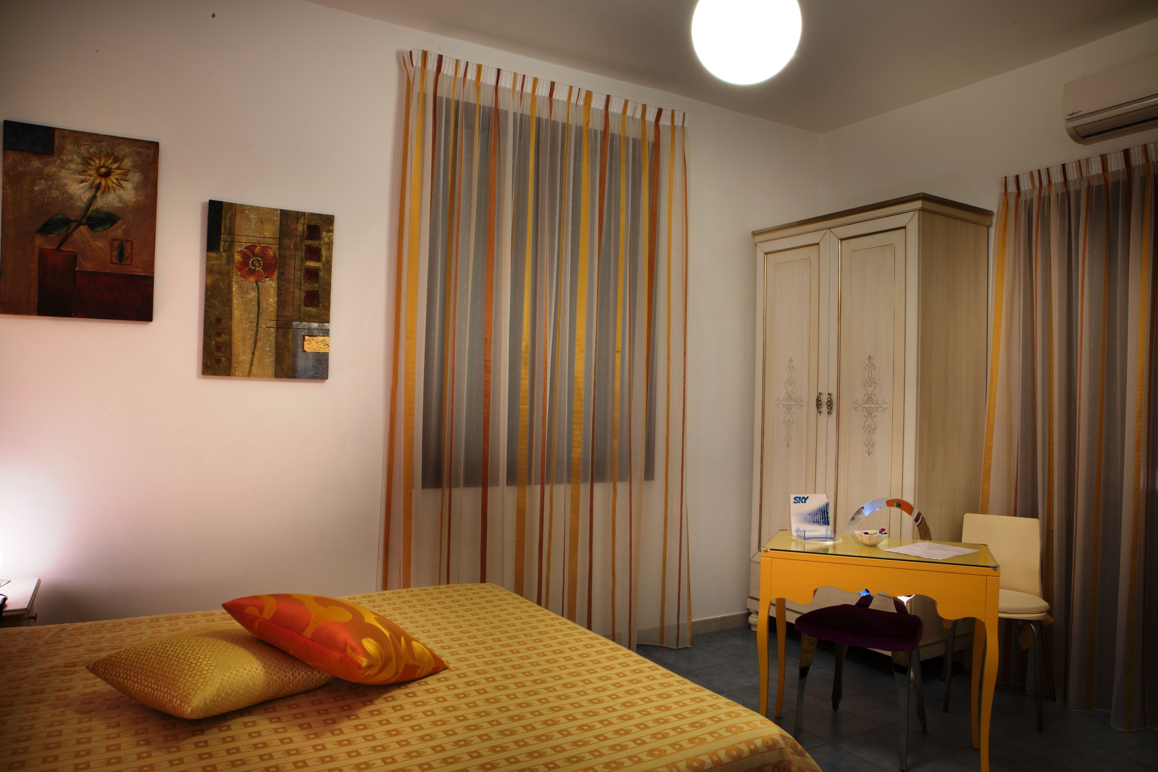 Una habitación de hotel con una cama, un escritorio y un armario.