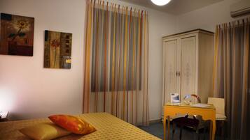 Una habitación de hotel con una cama, un escritorio y un armario.