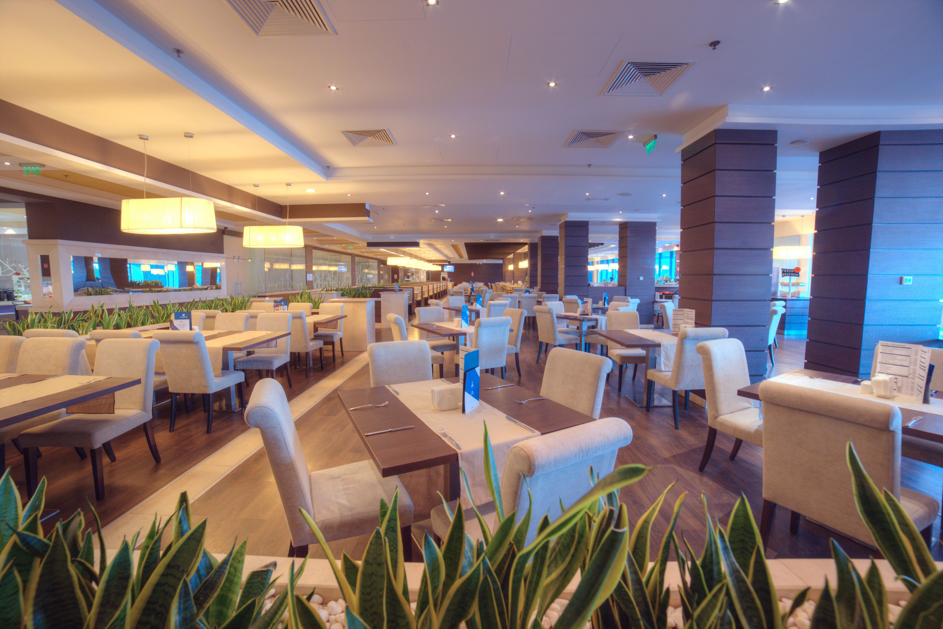 A spacious hotel lobby with multiple seating areas, including a bar and a dining area.