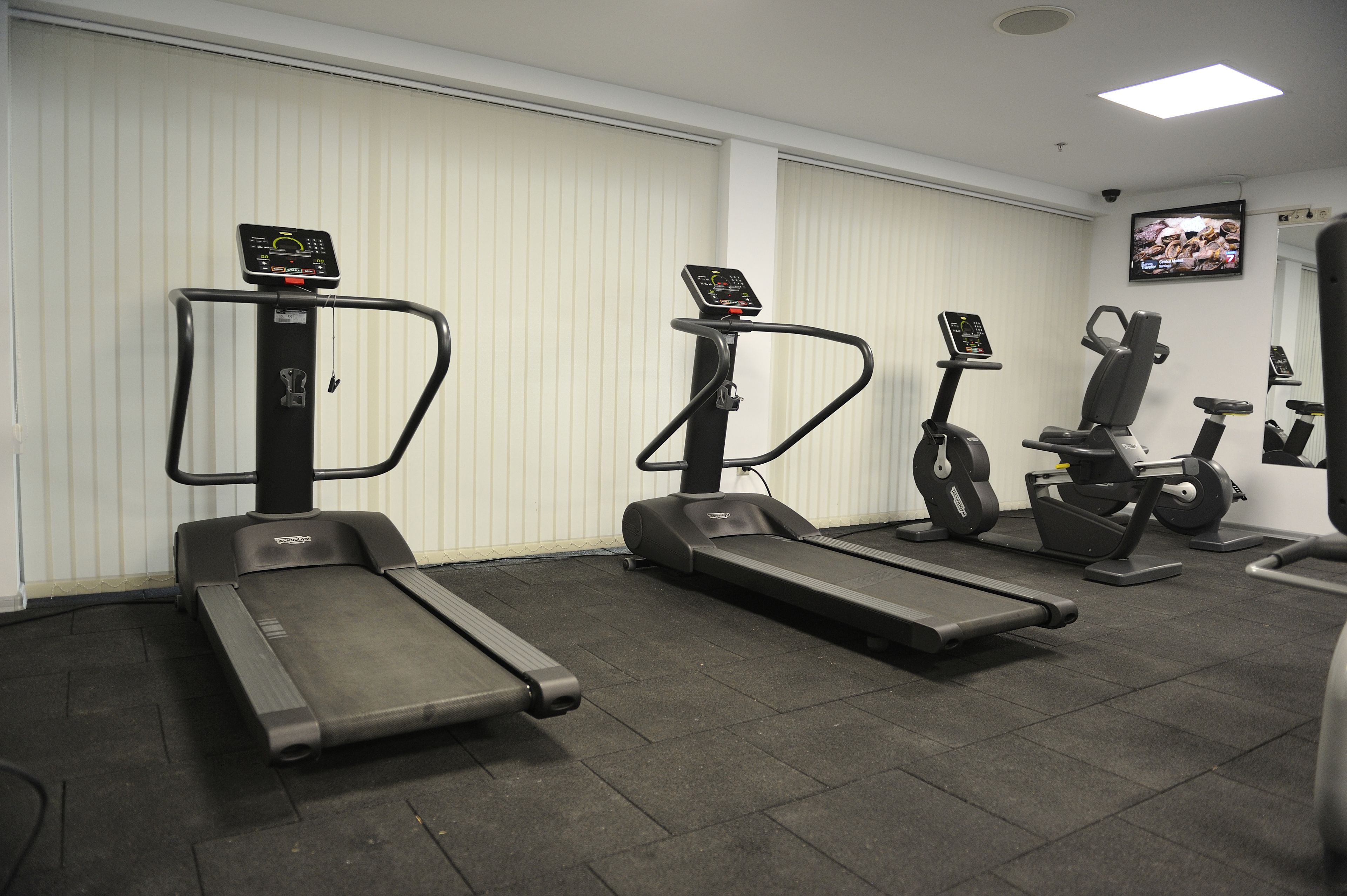 A gym with treadmills, elliptical machines, and a stationary bike.
