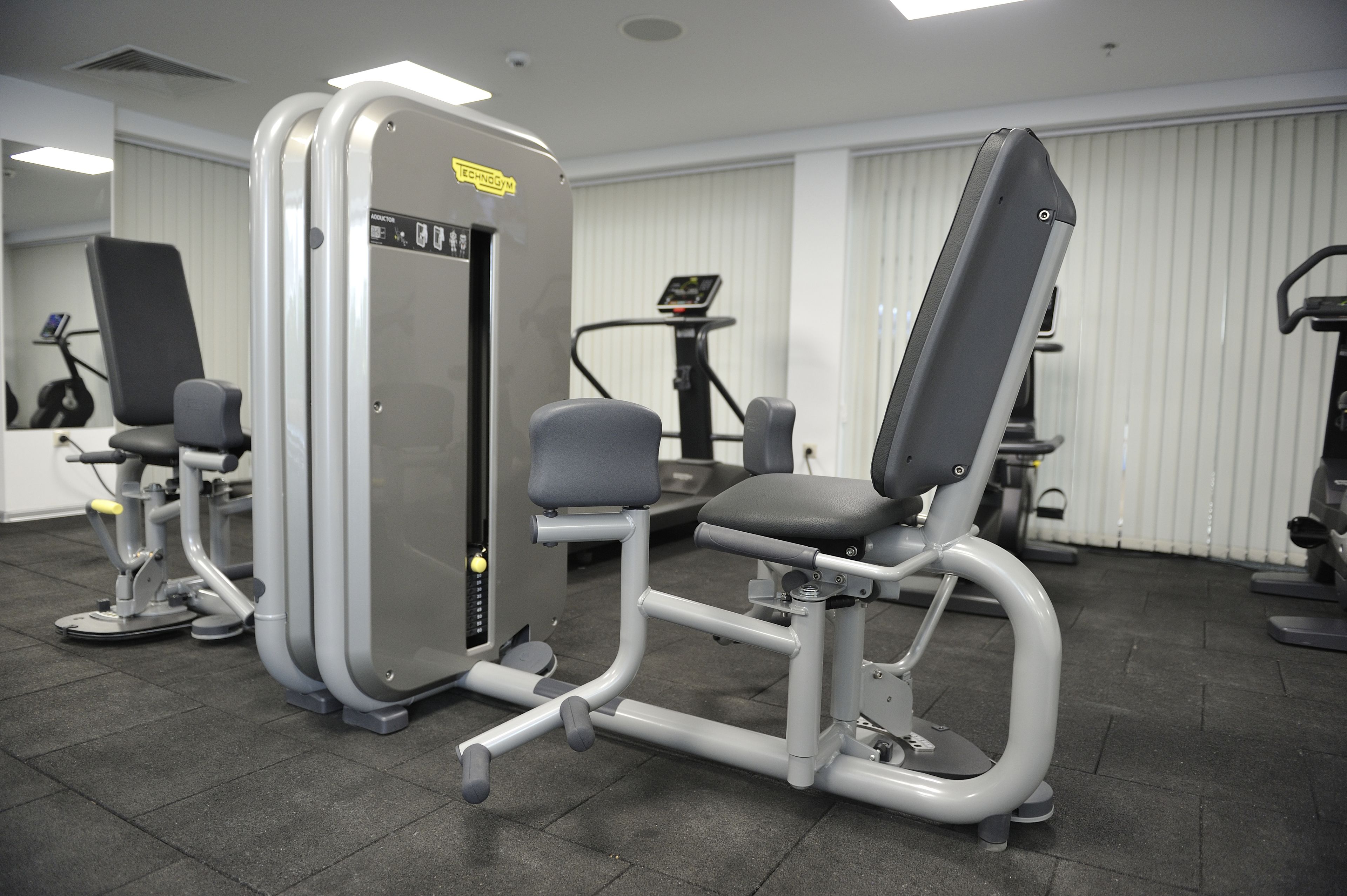 A gym with exercise equipment, including a leg press machine and a bench press.