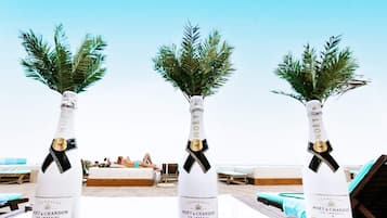 Three bottles of Moët & Chandon Ice Imperial champagne on a wooden table at a beachside resort.