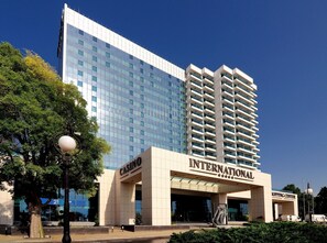 Un hôtel moderne, reconnaissable à son grand panneau indiquant la présence d’un casino, ainsi qu’à un centre commercial et à un immeuble imposant aux fenêtres réfléchissantes.