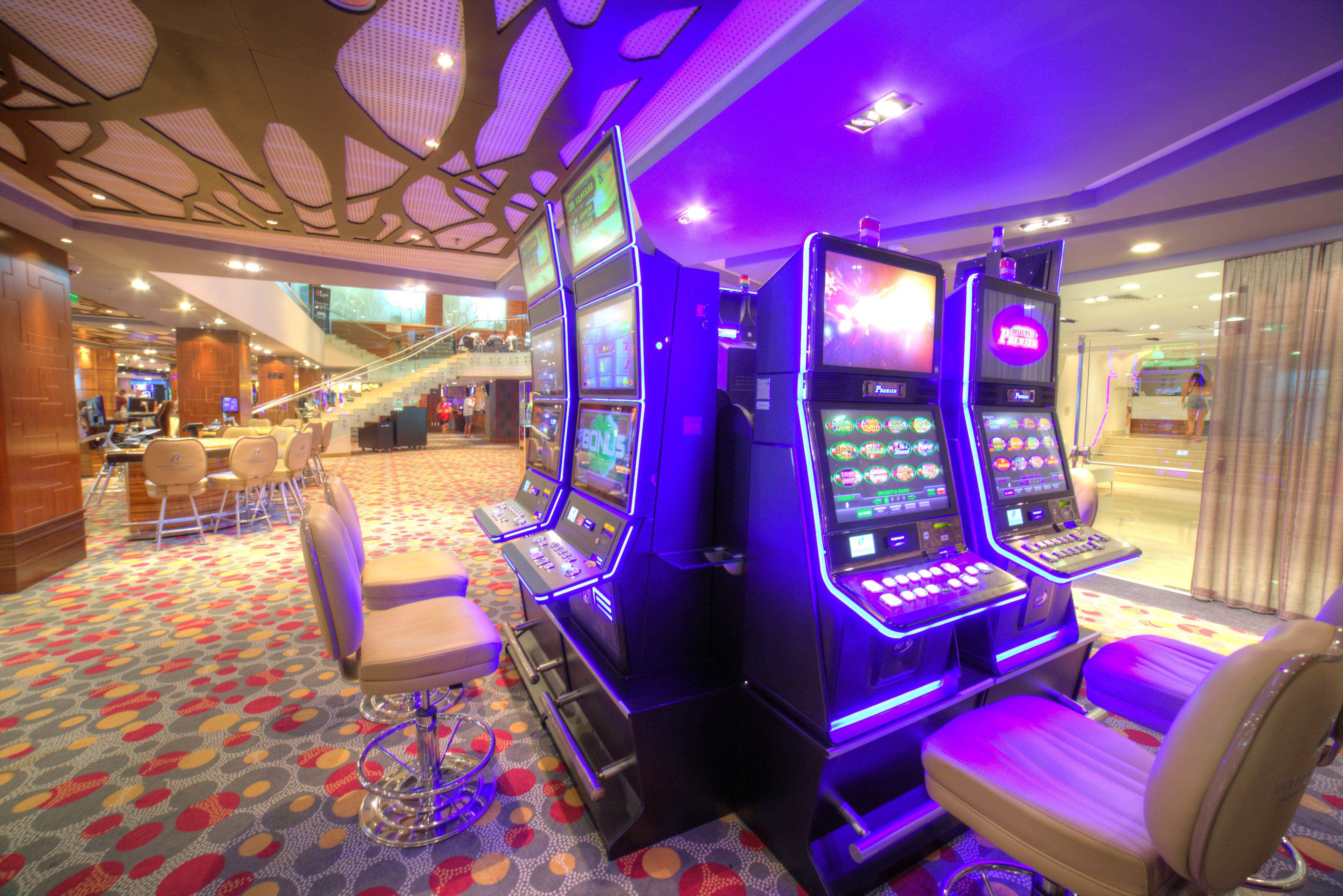 A casino area with slot machines and a large staircase.