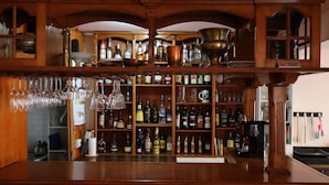A bar area with shelves of liquor bottles, glasses, and a prohibition sign. - Valle Frio Ushuaia (Ushuaia)