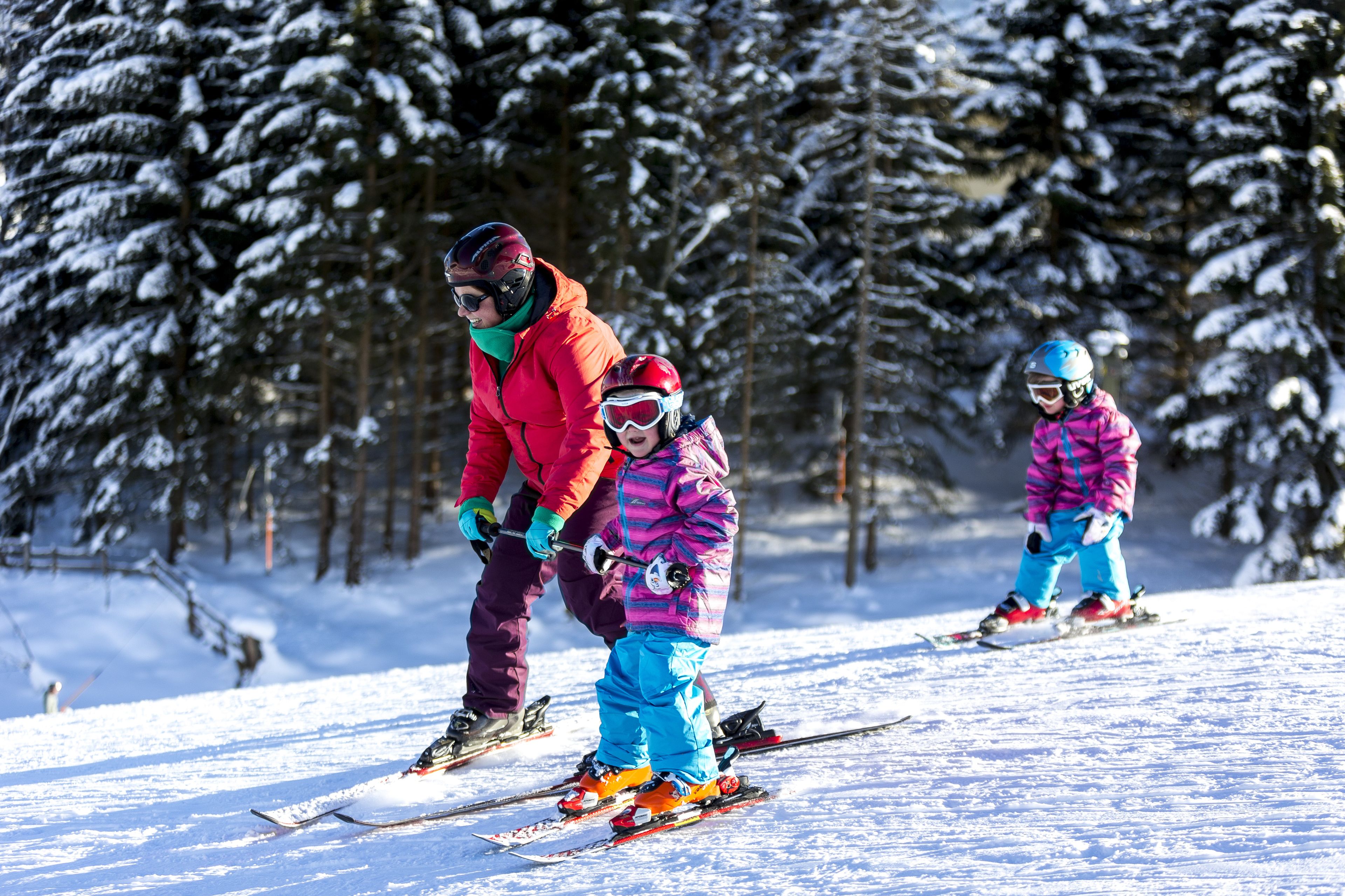 A snowy ski slope with trees in the background.
