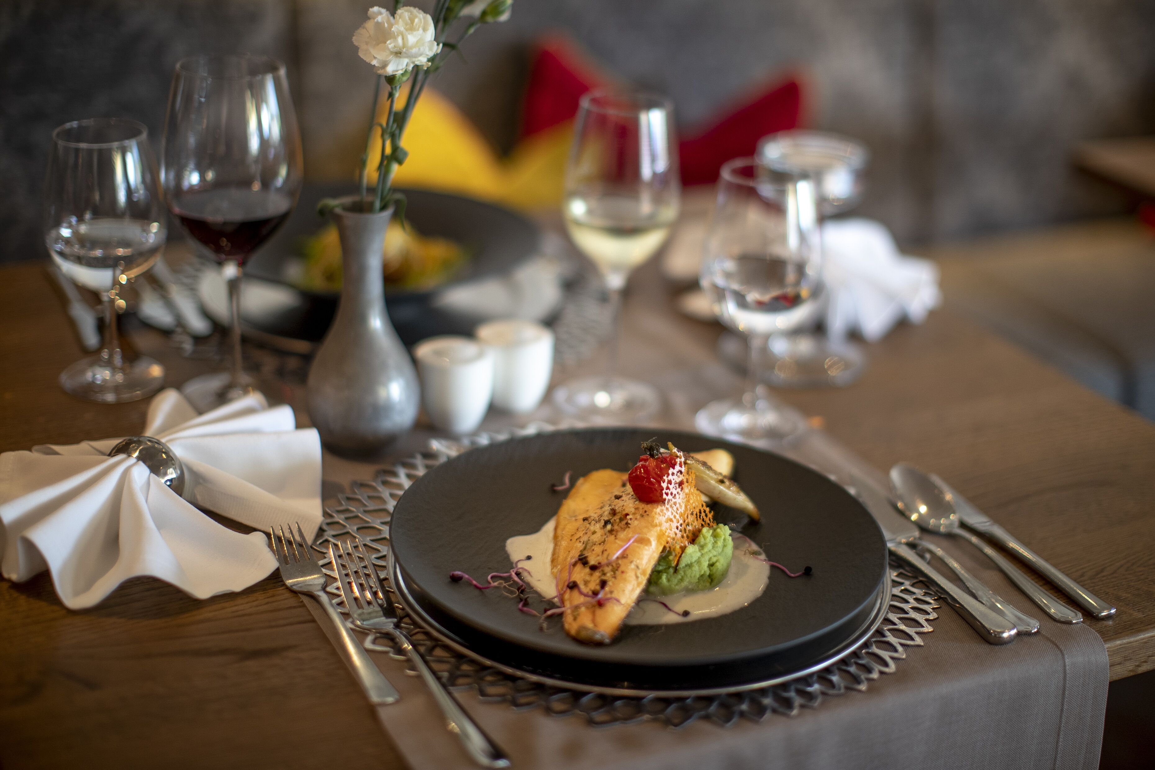 A dining table set with a plate of food, cutlery, and glasses.