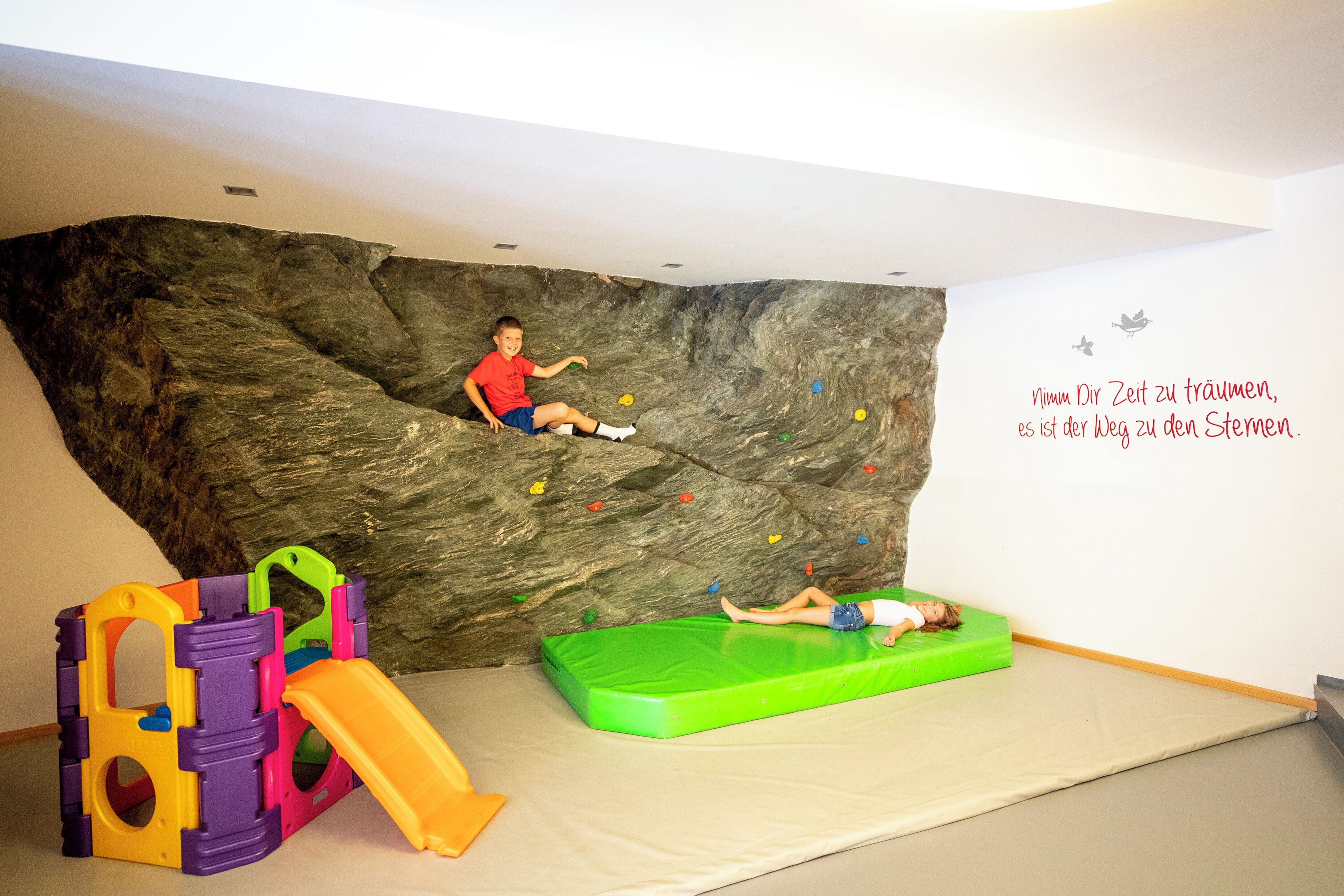 A play area with a climbing wall and a slide.