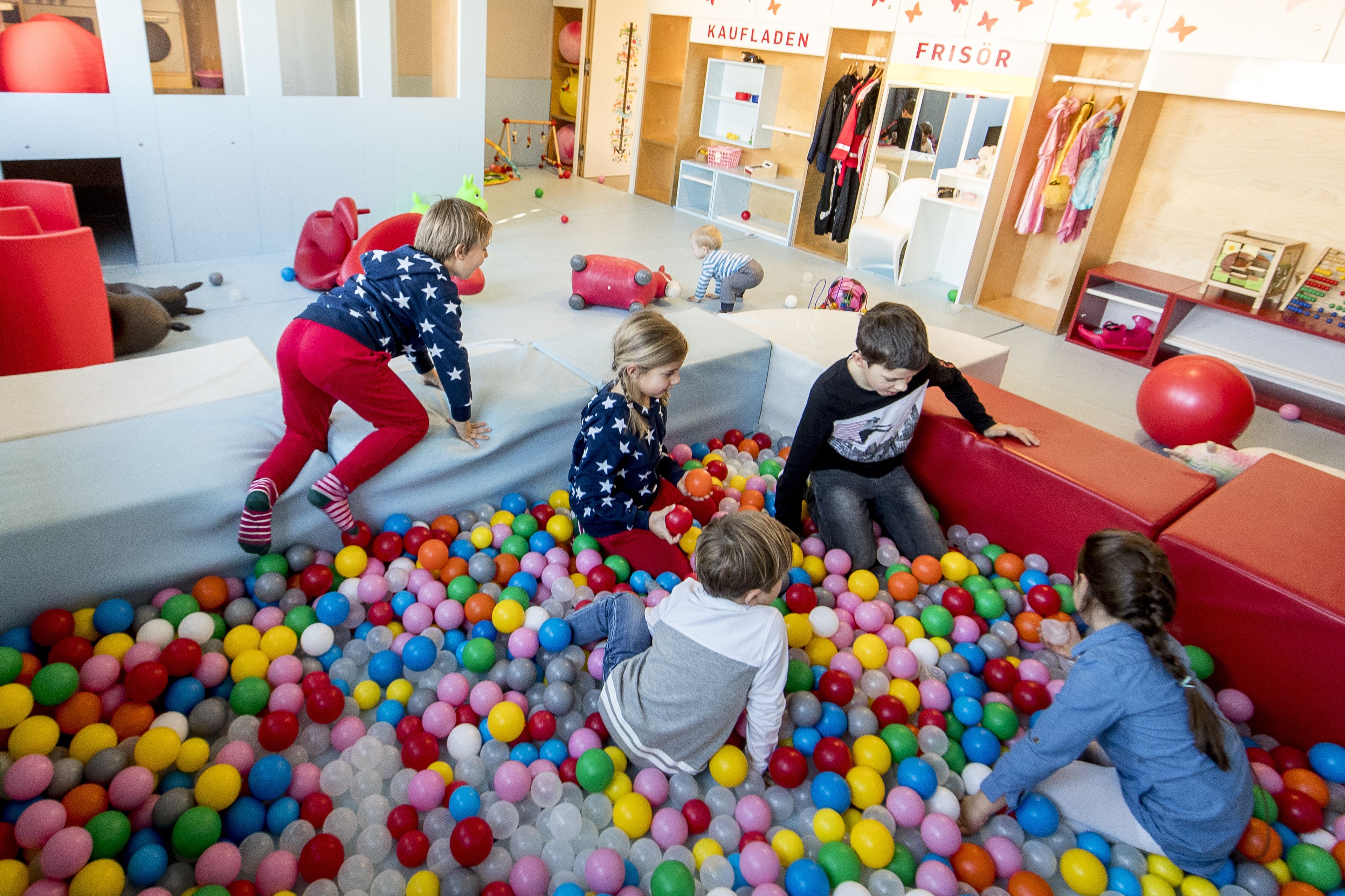 A children's play area with colorful balls and soft play structures.