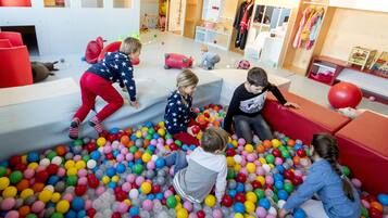 A children's play area with colorful balls and soft play structures.