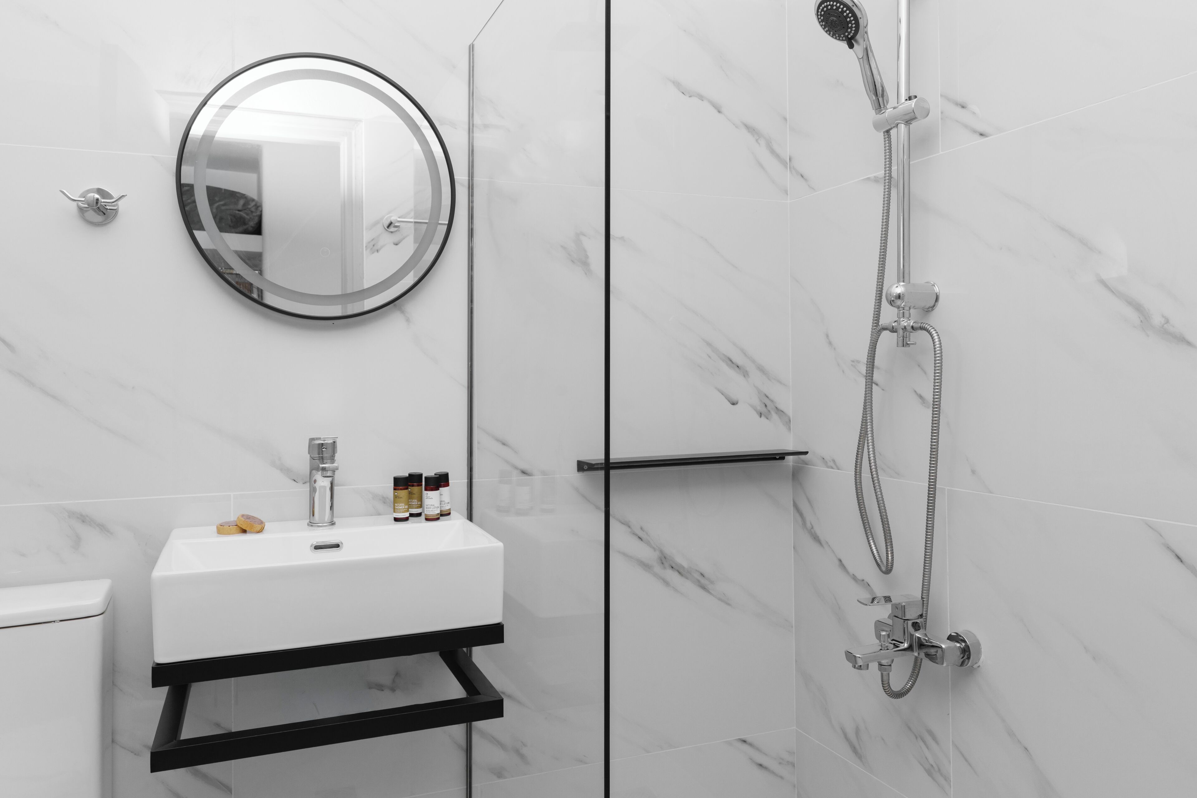 A modern bathroom with a white sink, mirror, and shower.
