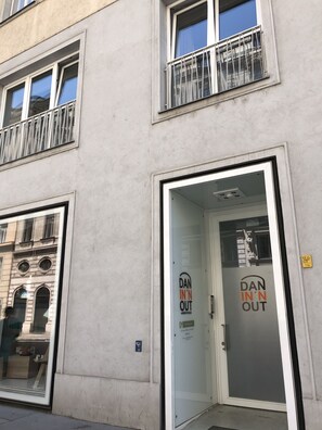 A building with a glass door labeled "DAN IN'N OUT" and a visible fire escape.