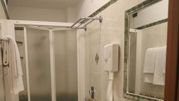 A bathroom with a shower, toilet, and sink.
