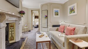A living room with a fireplace, a sofa, a coffee table, and a mirror. - Waterloo Townhouse & Suites (Dublin)