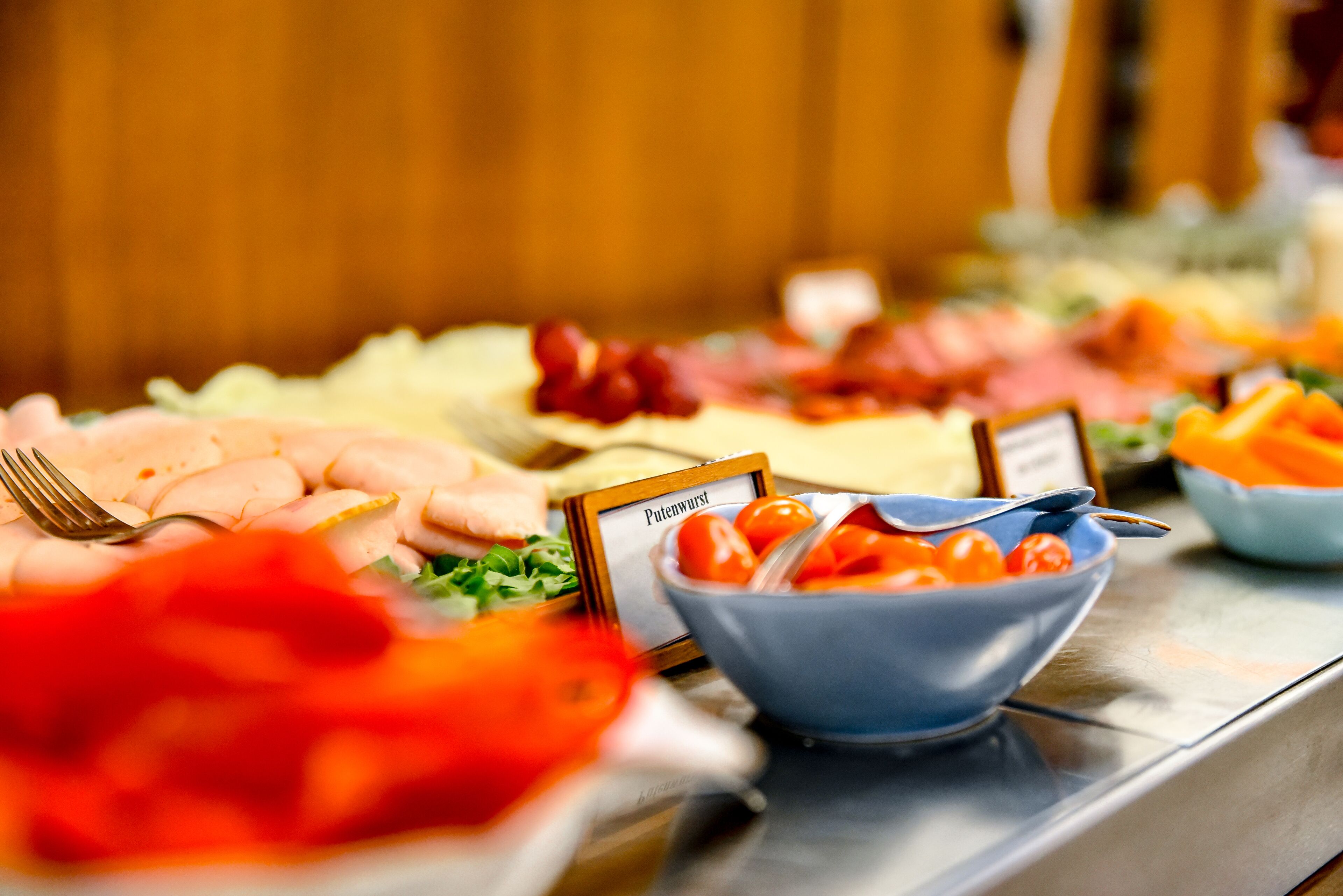 A buffet with various food items and a sign indicating 'Putenwurst.'