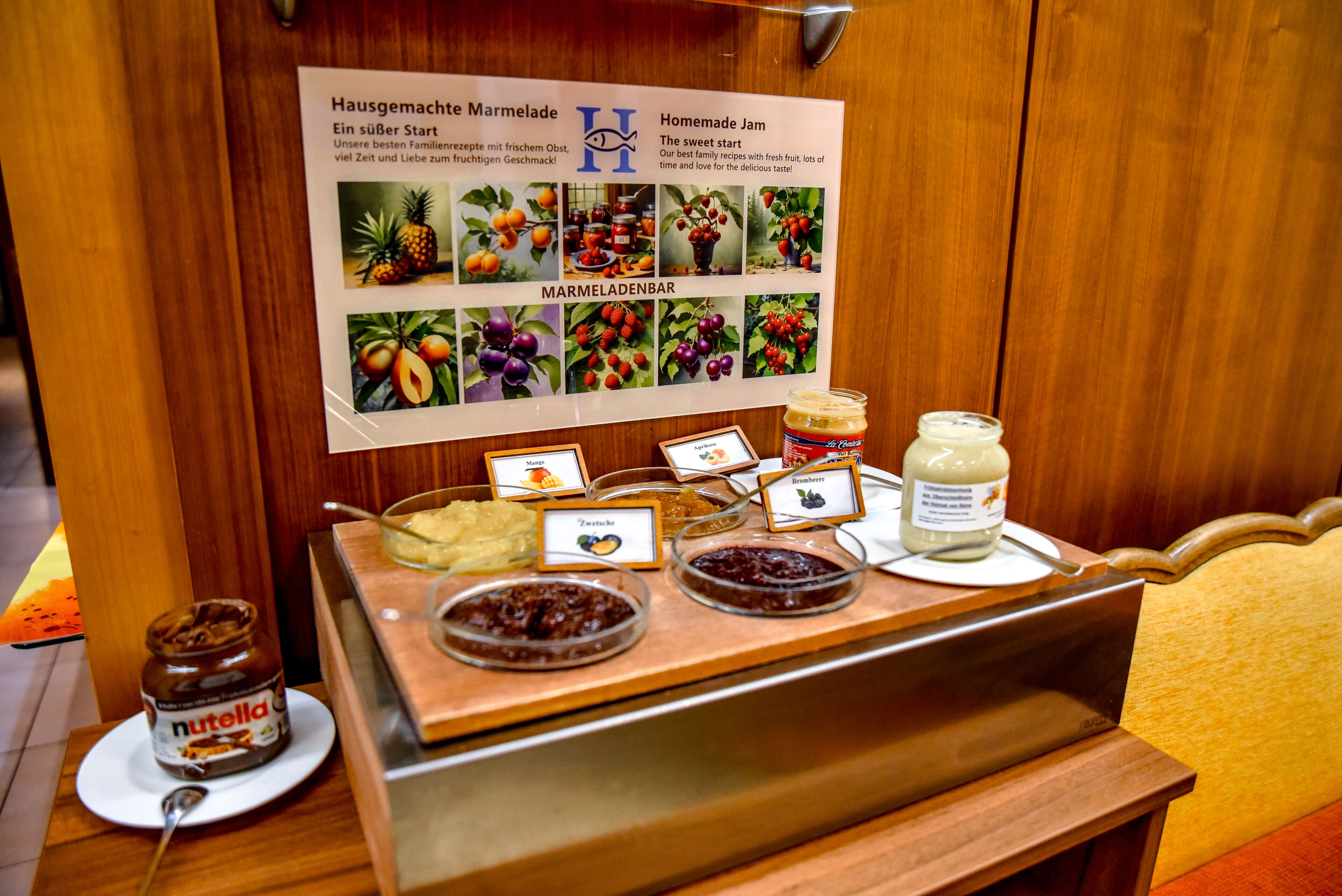 A buffet counter with various food items and a signboard with fruit images and text.